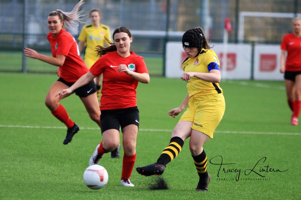 A Cyncoed Ladies player and Briton Ferry Llansawel player compete for the ball.