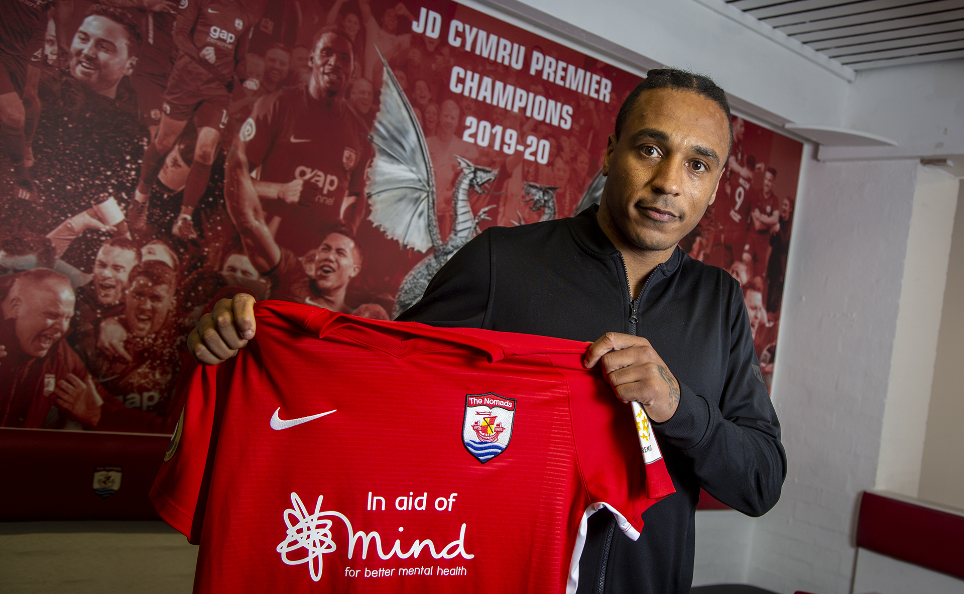 Neil Danns holds up a Connah's Quay Nomads shirt