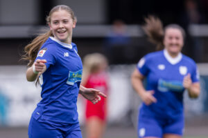 Cardiff City's Eliza Collie points to the camera as she celebrates a goal.