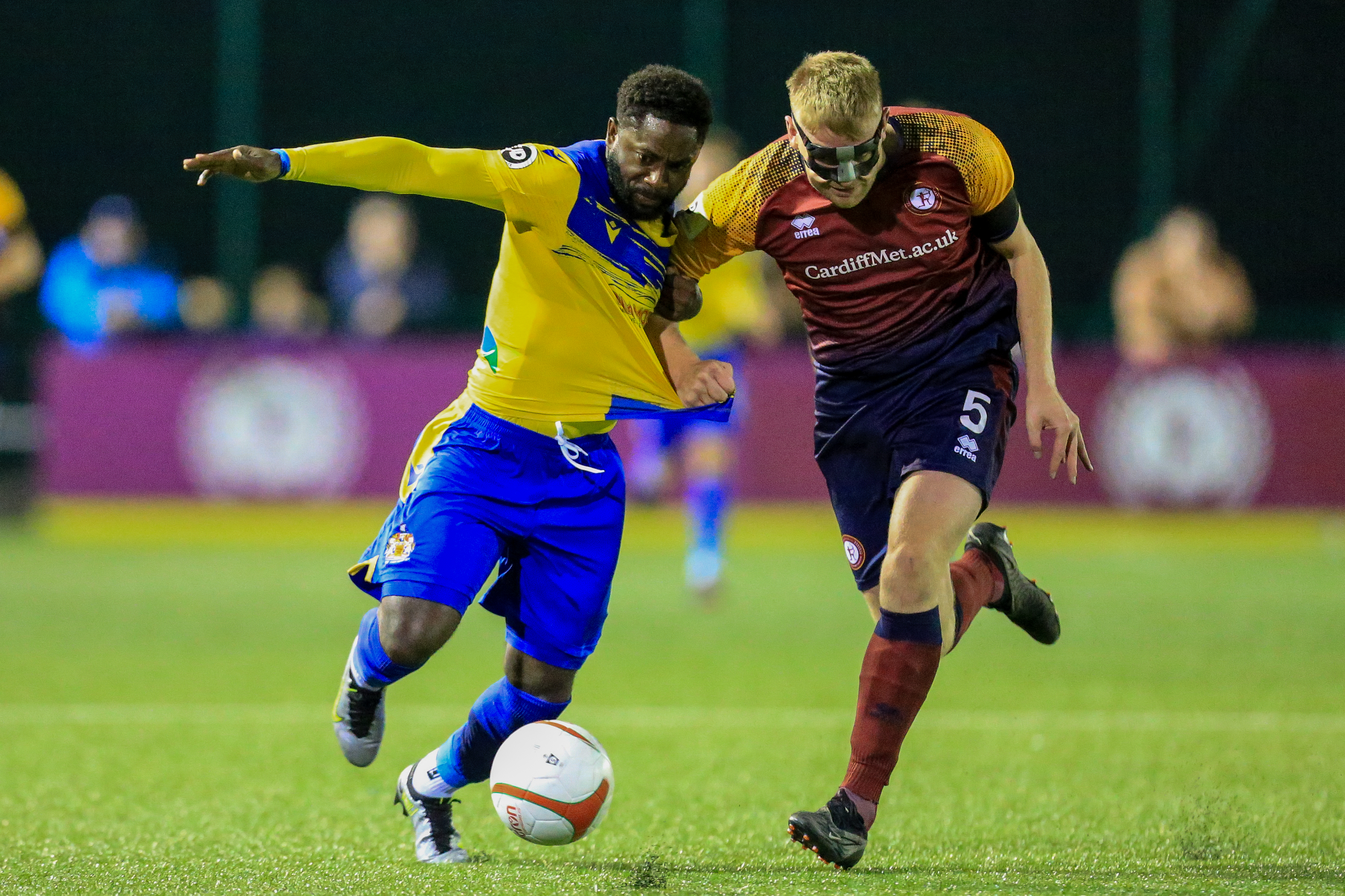 Barry Town's Kayne McLaggon and Cardiff Met's Emlyn Lewis competing for the ball.