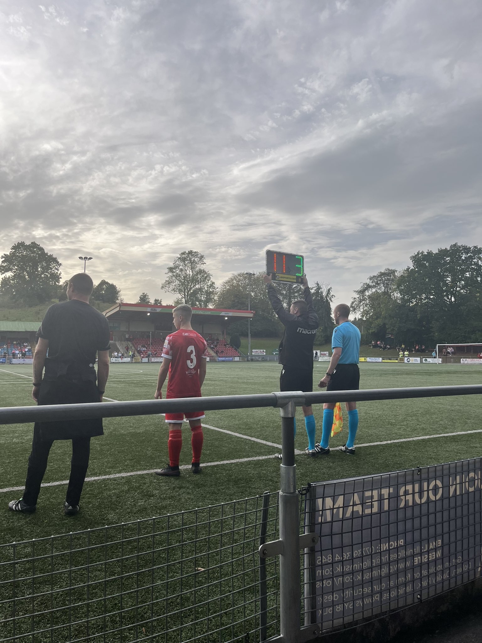 Newtown player Arnie Roberts standing on the touchline.