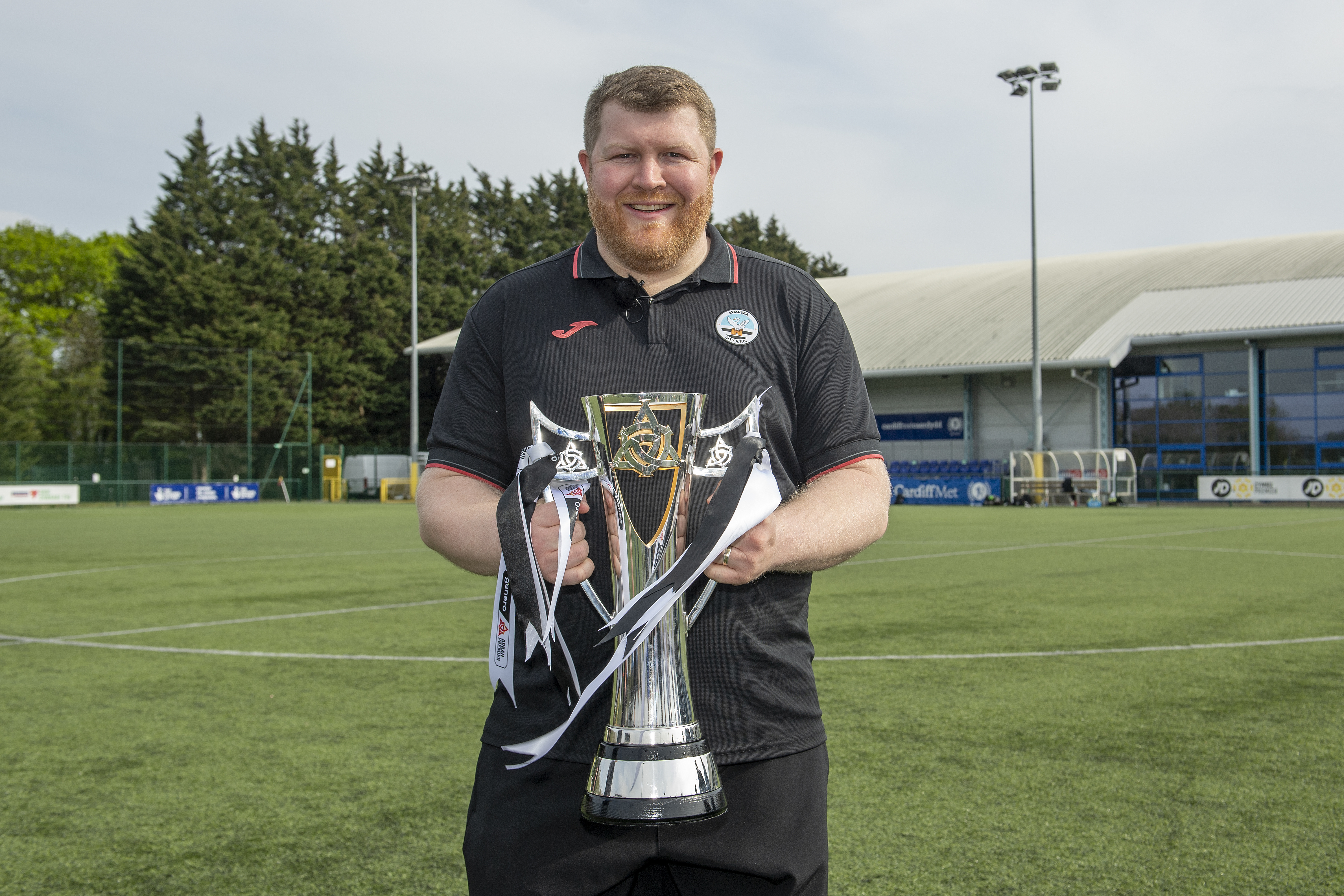 Swansea City interim boss Chris Church poses with the Genero Adran Premier trophy.