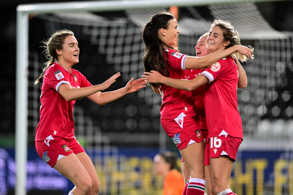 Carra Jones celebrates with her Wrexham teammates after scoring against Swansea City.