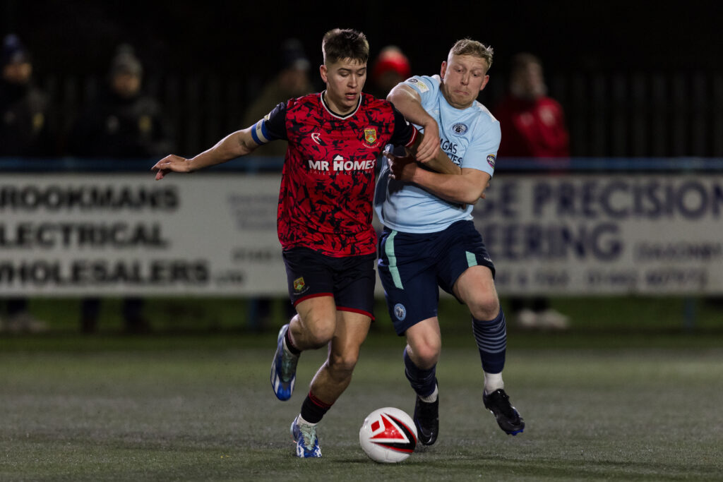 Caerau Ely's Jack Ashford jostles for possession with a Cambrian United player. 