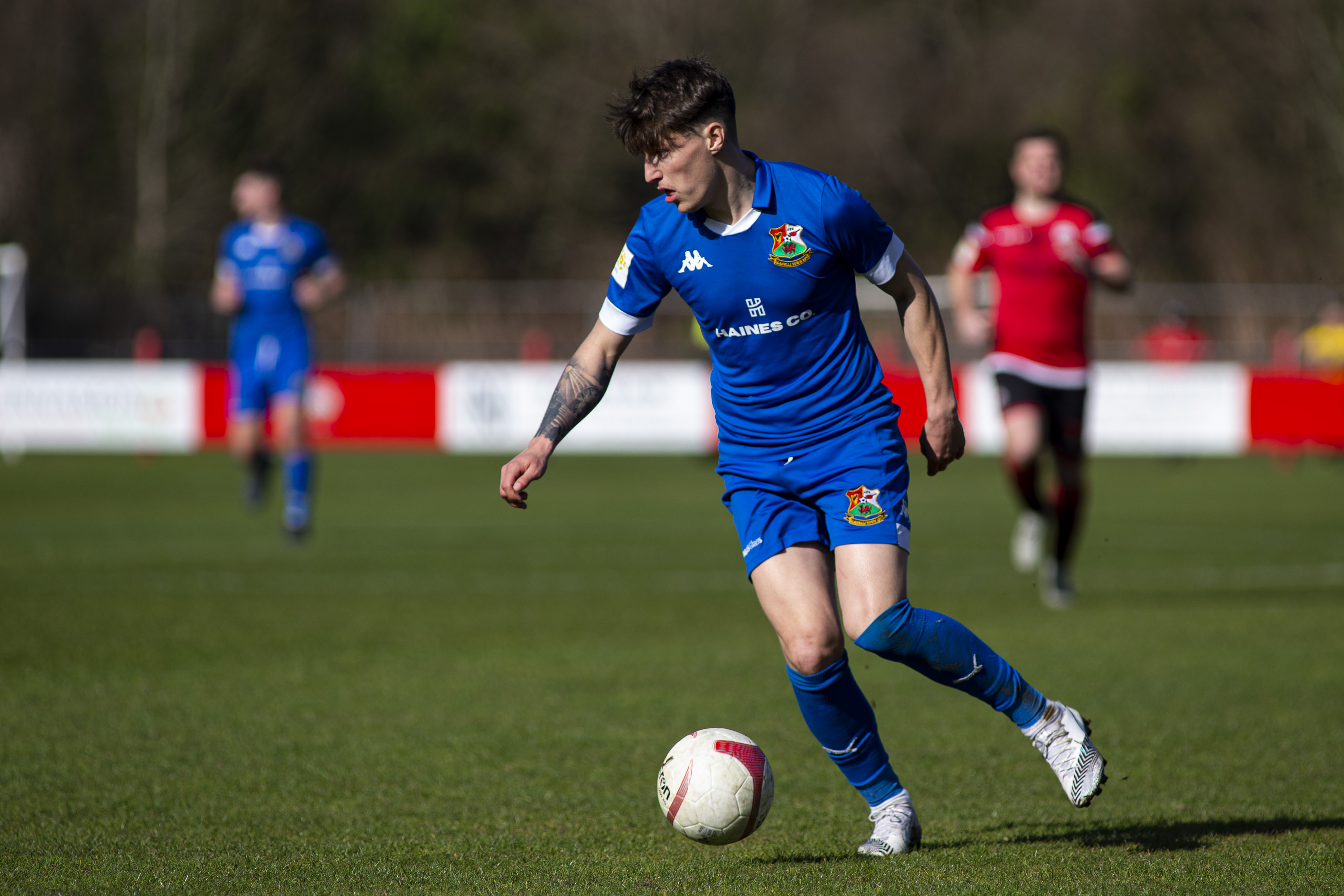 Llanelli Town player Thomas Hillman in possession with the football.