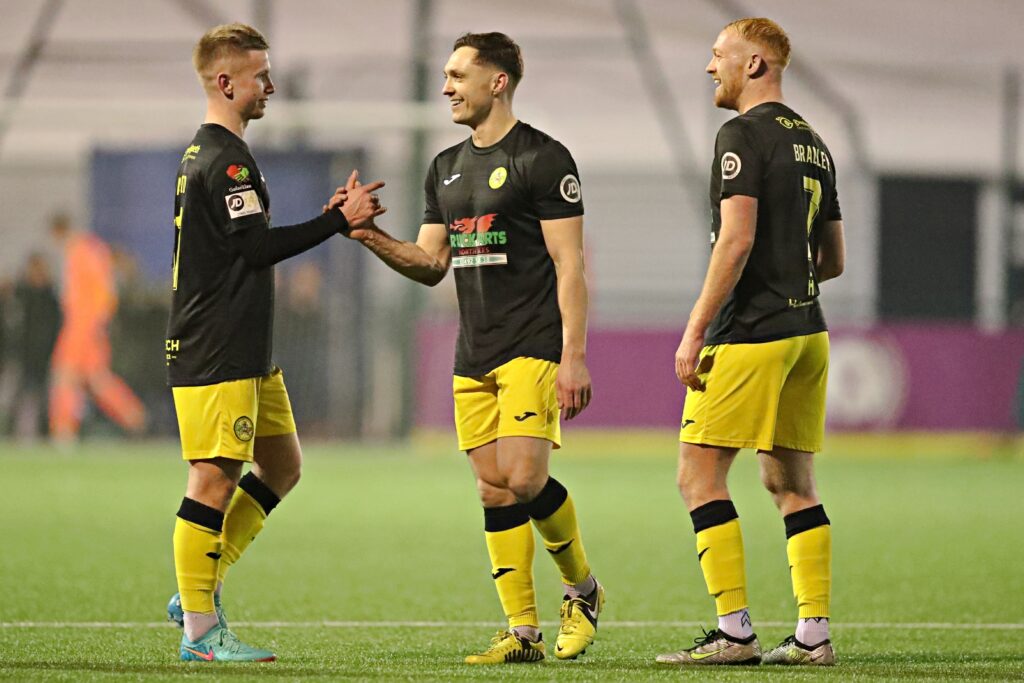 Sion Bradley, Danny Gossett and Gwion Dafydd of Caernarfon Town celebrate after beating Cardiff Met in the Cymru Leagues Premier. 