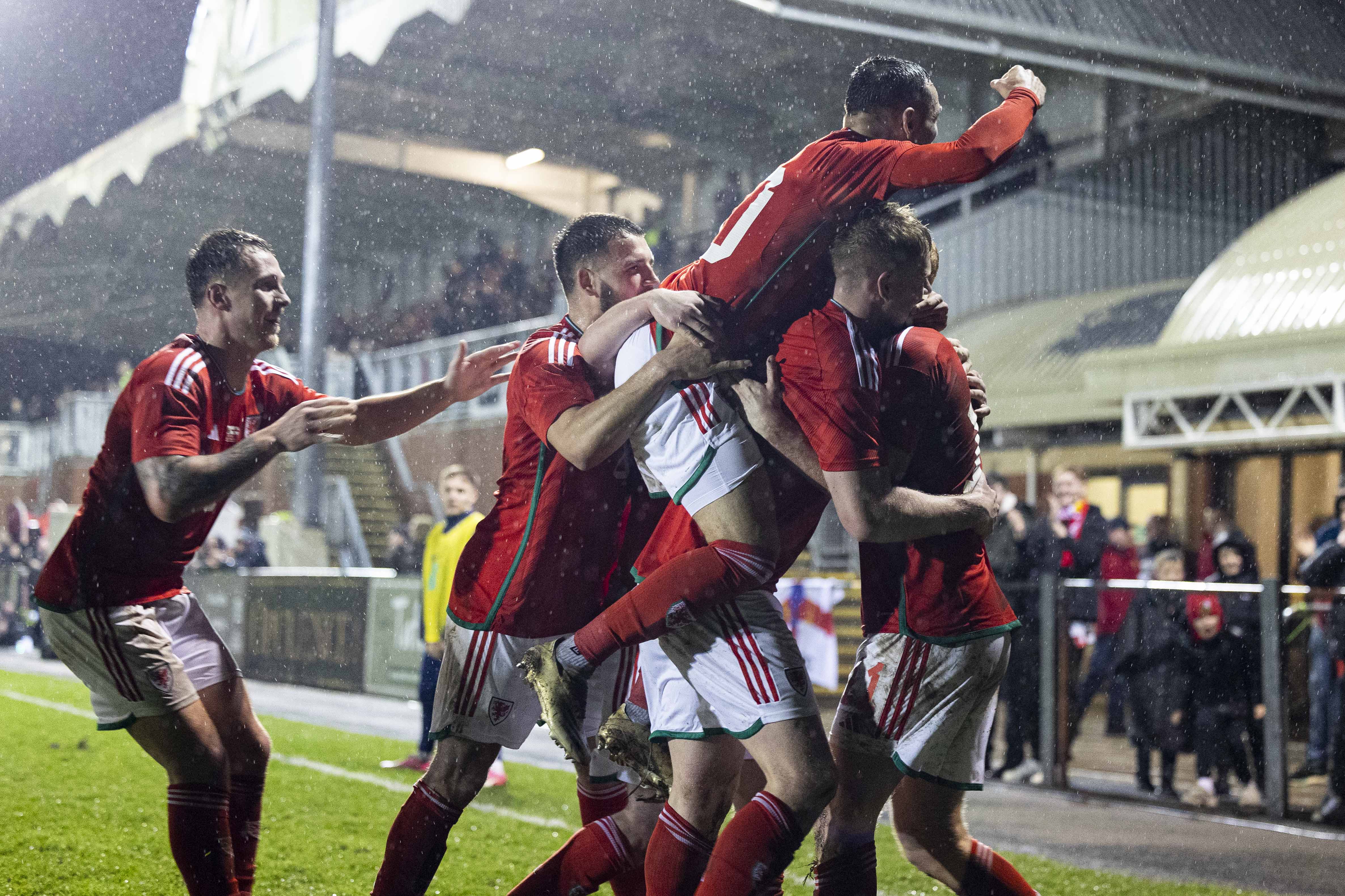 Wales C players celebrate with Sion Bradley after scoring against England