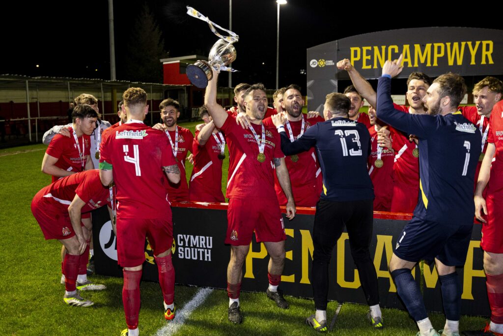 Luke Bowen lifts the Cymru South title with his Briton Ferry teammates. 