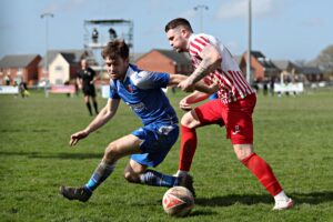 Ruthin's Gwion Owen is pressured by Holywell's Jamie Breese during Ruthin Town vs Holywell Town in round 24 of the JD Cymru North at the Memorial Playing Fields, Ruthin