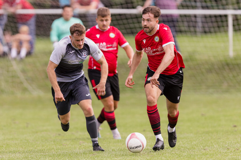 Penrhiwceiber's Scott Lewis and Baglan Dragons' Jonathan Davies  during the 2024/25 JD Cymru South League fixture between Penrhiwceiber Rangers F.C. & Baglan Dragons FC