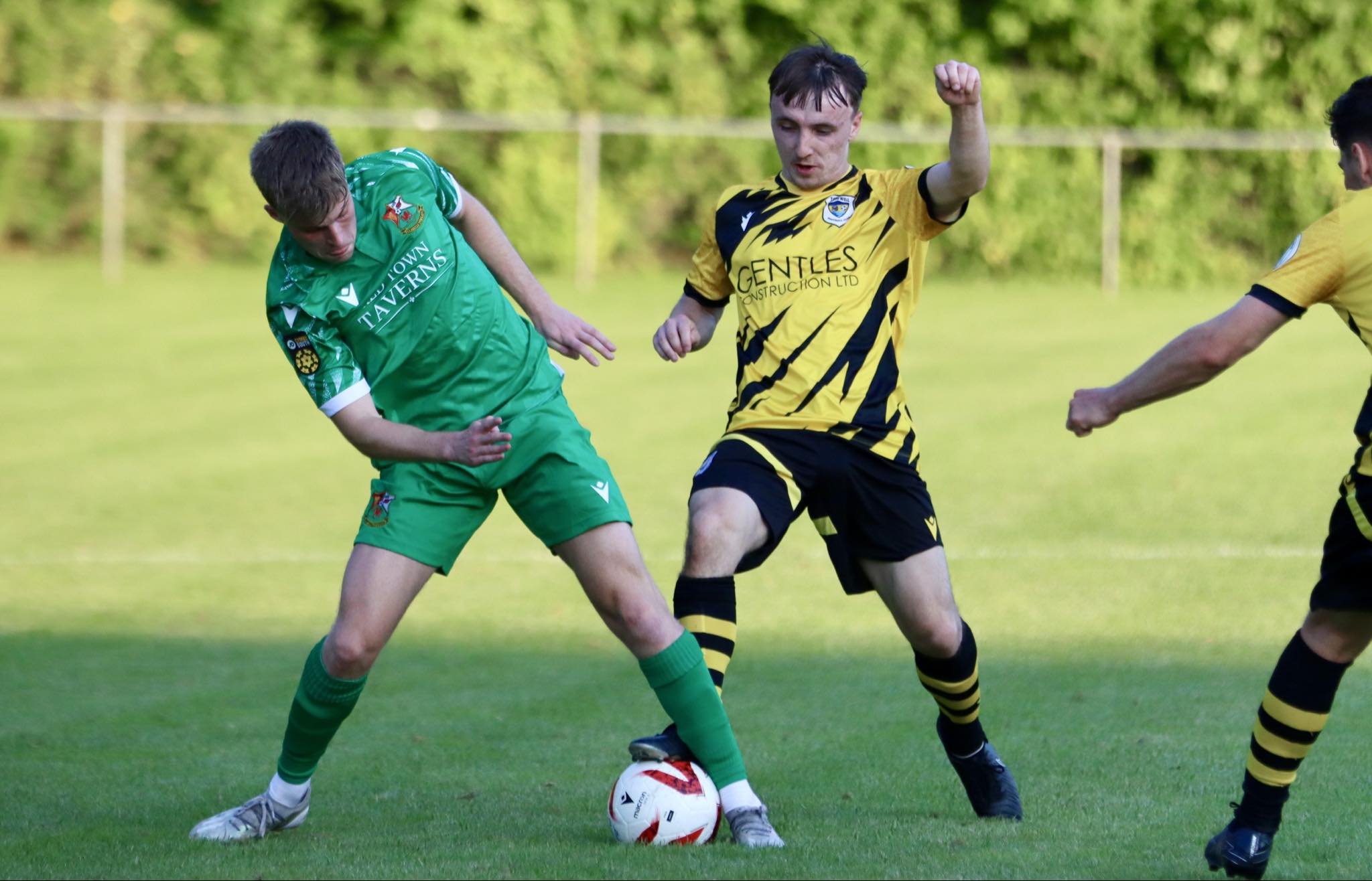 David Lyon of Taffs Well battles a Llanelli Town player for the ball in a Cymru South match.