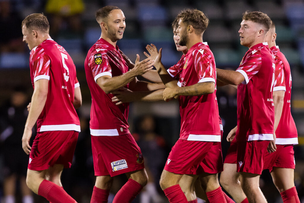 Llanelli's Josef Hopkins scores to level the game 1-1 and celebrates during the 2024/25 Nathaniel MG Cup fixture between Barry Town United F.C & Llanelli Town AFC