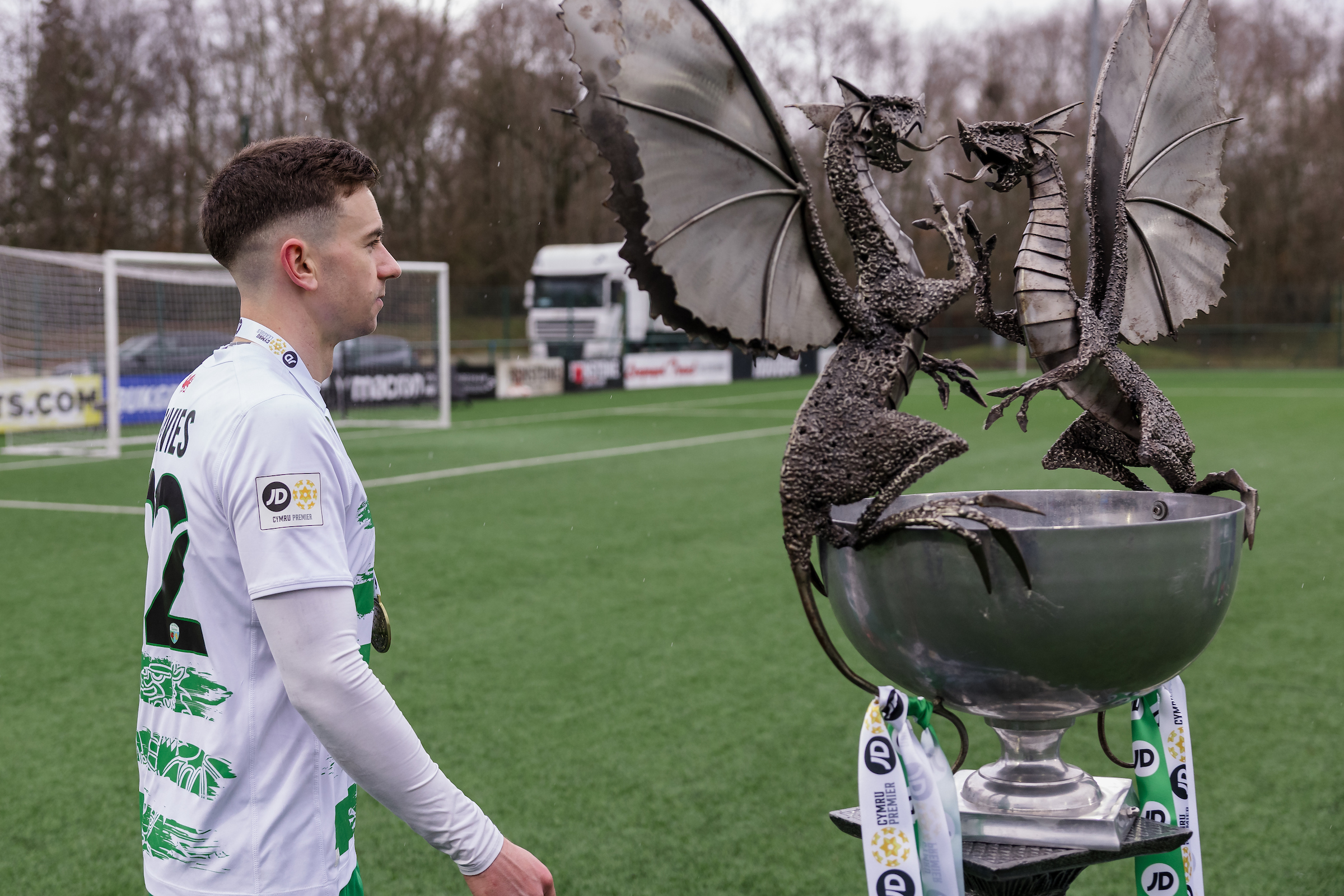 Danny Davies walks past the Cymru Premier trophy