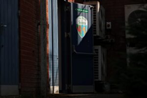 A door with a TNS badge on it at Park Hall, ahead of a UEFA Conference League qualifier