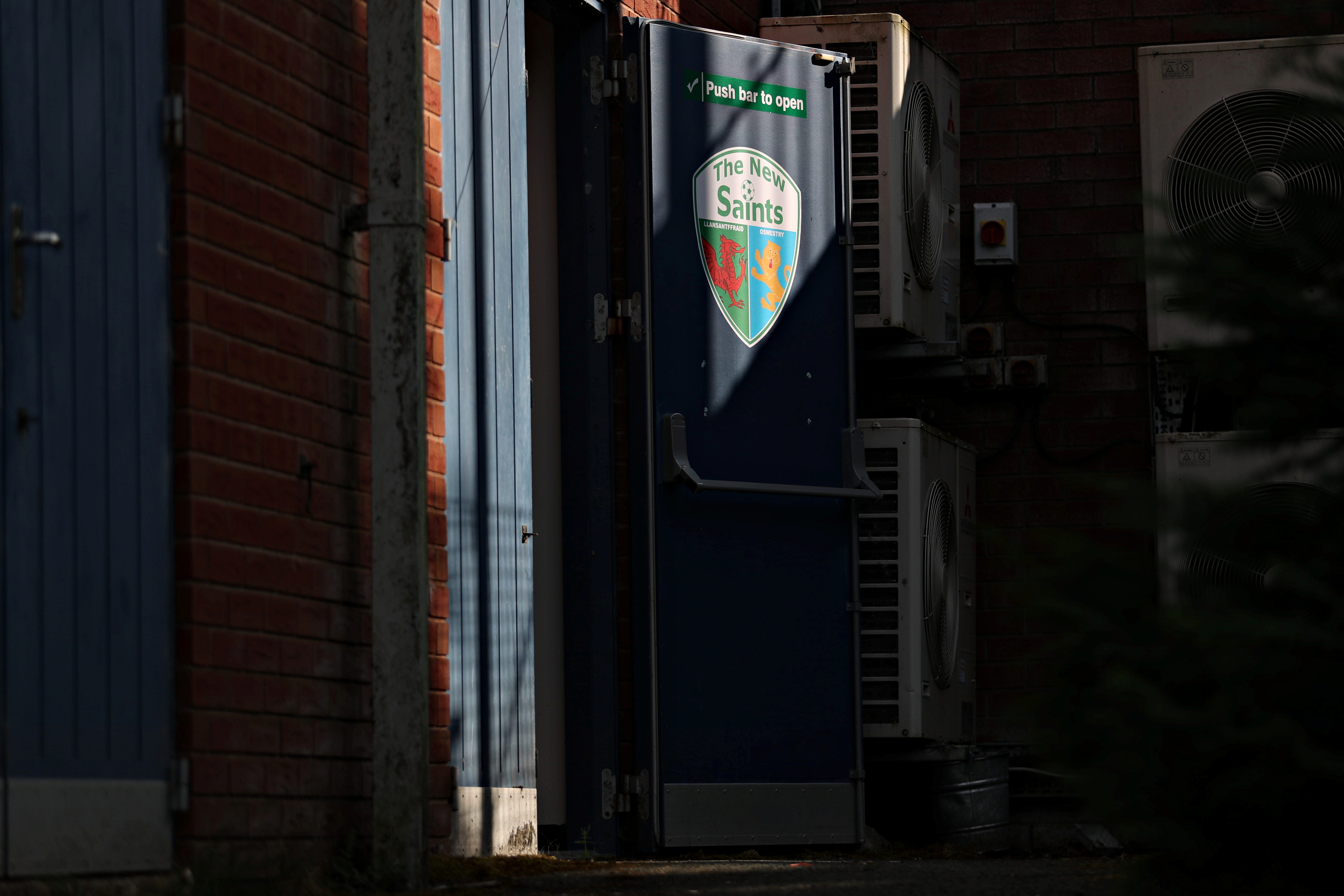 A door with a TNS badge on it at Park Hall, ahead of a UEFA Conference League qualifier