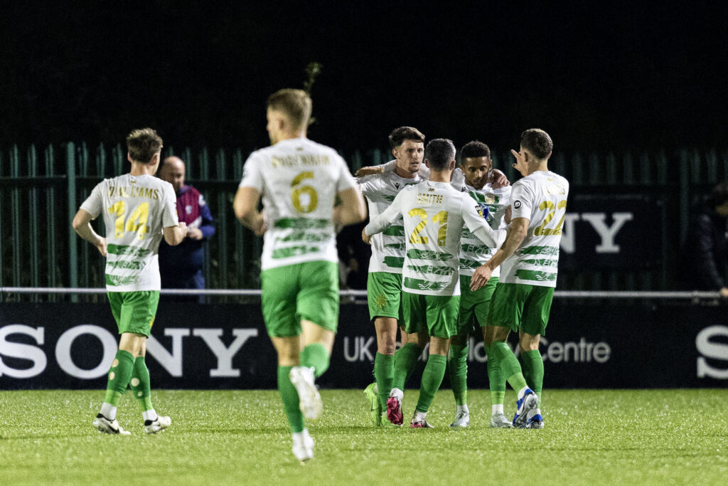 Adam Wilson celebrates with his teammates after scoring for TNS against Penybont