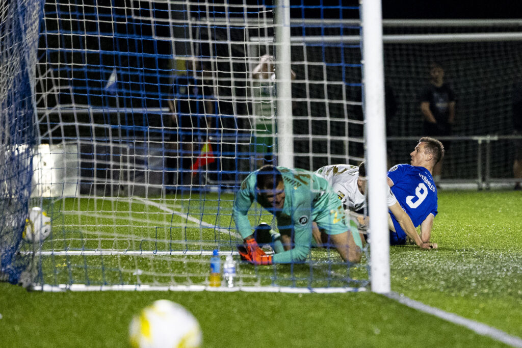 Chris Venables of Penybont and Connor Roberts of TNS look on as the ball goes in to the back of the net