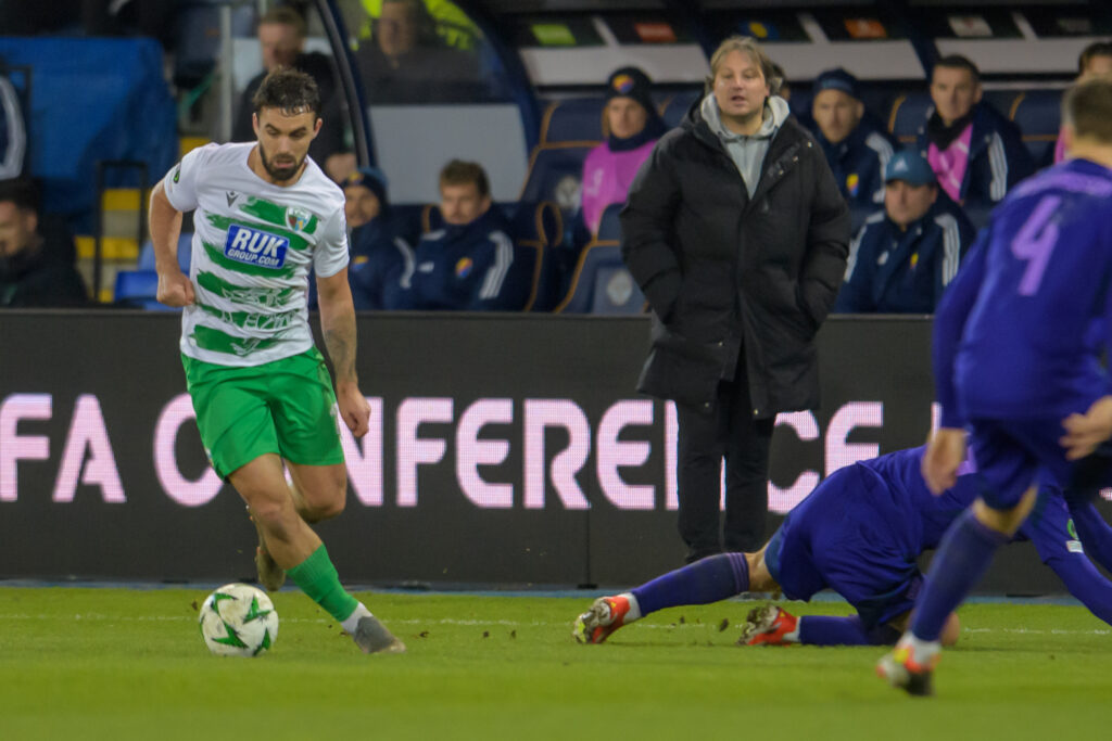 TNS' Jordan Williams dribbles with the ball against Djugardens with Craig Harrison looking on