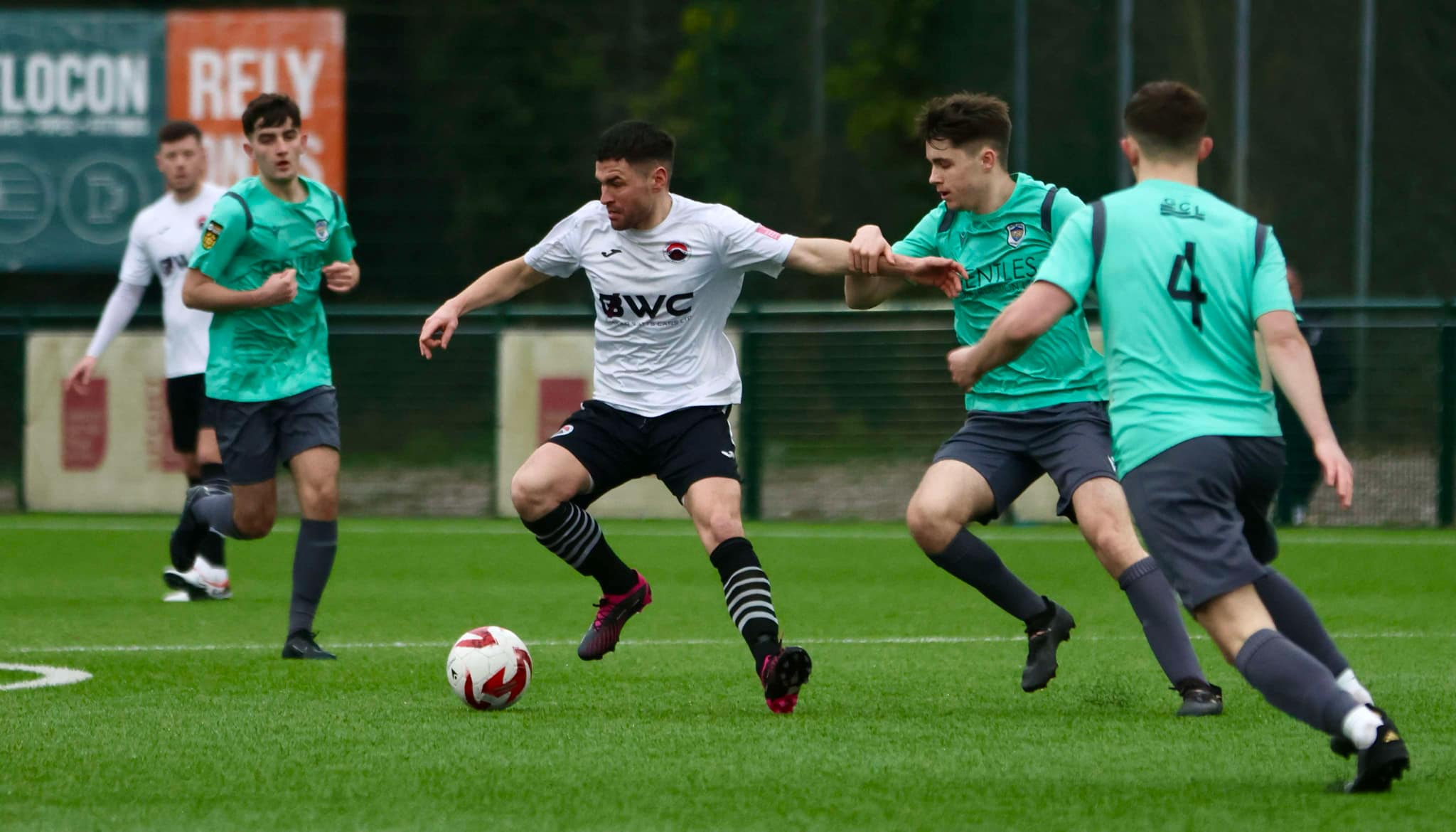 Pontypridd United's Ashley Evans jostles for possession with a Taffs Well player in a Cymru South match.