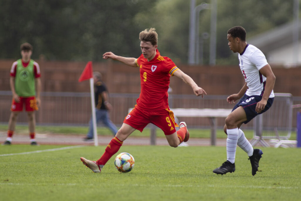 Newport, WALES - 3 September, 2021: Iwan Roberts of Wales u18 in action against Lee Jonas of England u18. Wales u18 v England u18 friendly at Spytty Park on the 3rd September 2021