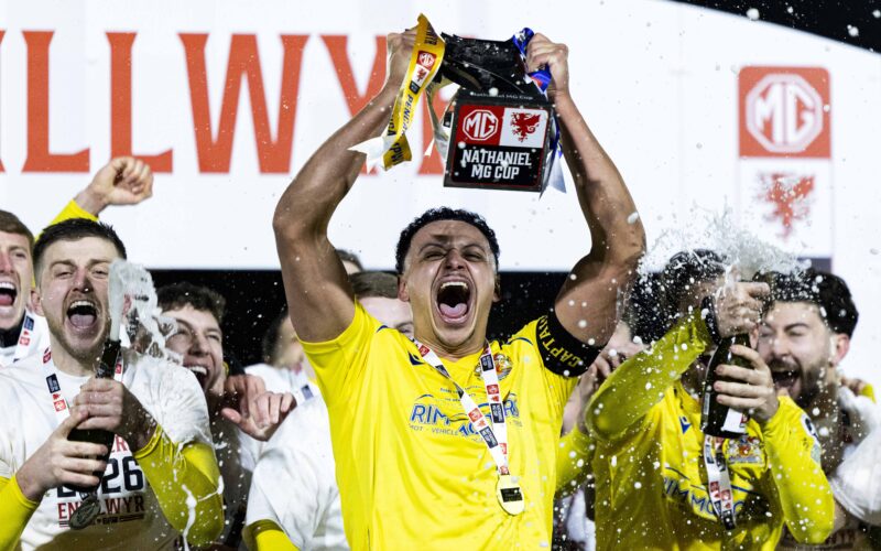 BRIDGEND, WALES - 28 FEBRUARY 2026: Barry Town's Callum Sainty lifts the trophy during the 2025/26 Nathaniel MG Cup Final fixture between The New Saints FC & Barry Town United AFC at the Dragonbet Stadium, Bridgend, Wales
