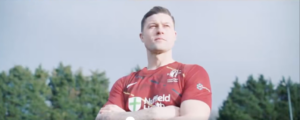 Former Newport County defender James Clarke with his arms folded as he poses in a Cardiff Met shirt.