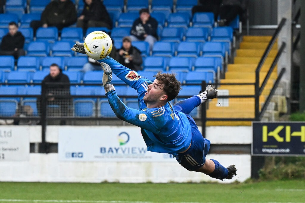 COLWYN BAY, WALES - 08 March 2026: Alex Swindell of Rhyl 1879 makes a save during the JD Welsh Cup Semi-Final between Rhyl 1879 and Caernarfon Town at The Blue Turtle Arena in Colwyn Bay