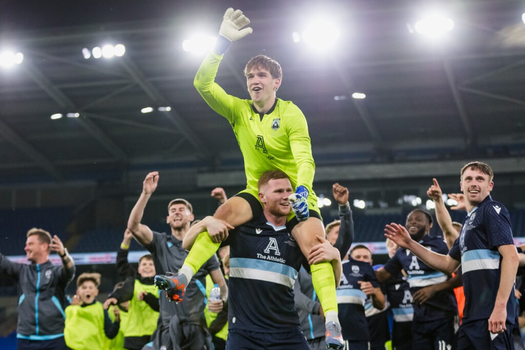 CARDIFF, WALES - 20 JULY 2023:  Haverfordwest County's goalkeeper Zac Jones and Haverfordwest players celebrate winning the game on penalty kicks after extra time of the UEFA Europa Conference League qualifier second leg fixture between Cymru premier’s Haverfordwest County & KF Shkëndija of North Macedonia at the Cardiff City Stadium, Cardiff, Wales.  (Pic by John Smith/FAW)