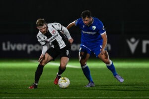 Mikey Burke of Flint Town United and Harrison McGahey of The New Saints compete for the ball during a JD Cymru Premier match between The New Saints and Flint Town United at Park Hall Stadium in Oswestry