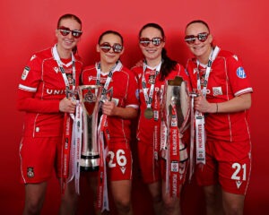 CEFN MAWR, WREXHAM, WALES - 5th APRIL 2026 - Evie Sadler, Maria Francis-Jones, Faye Knox and Lili Mai Jones of Wrexham AFC Women celebrate with the Genero Adran Trophy after Wrexham AFC Women vs Swansea City Women in Round 6 of the Genero Adran Premier Championship at The Rock, Cefn Mawr