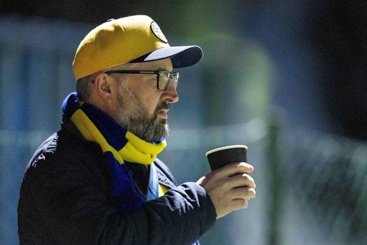 Cwmbran Celtic fan drinks a coffee during the 2025/26 JD Cymru South fixture between Cwmbran Celtic & Ynyshir Albions at Avondale Motorpark Arena, Cwmbran, Wales