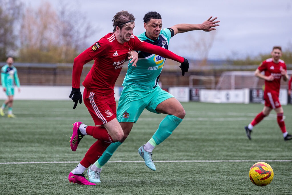 Connah's Quay Nomads' Harry Franklin and Barry Town's Callum Sainty battle for the ball during the JD Cymru Premier fixture between Connah’s Quay Nomads and Barry Town United at the Essity Stadium, Flint. 29th of March, Flint, Wales
