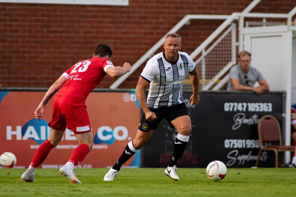Lee Trundle of Ammanford in action against Daniel Alfei of Llanelli Town
Llanelli Town v Ammanford in the JD Cymru South at Stebonheath Park on the 23rd July 2021.