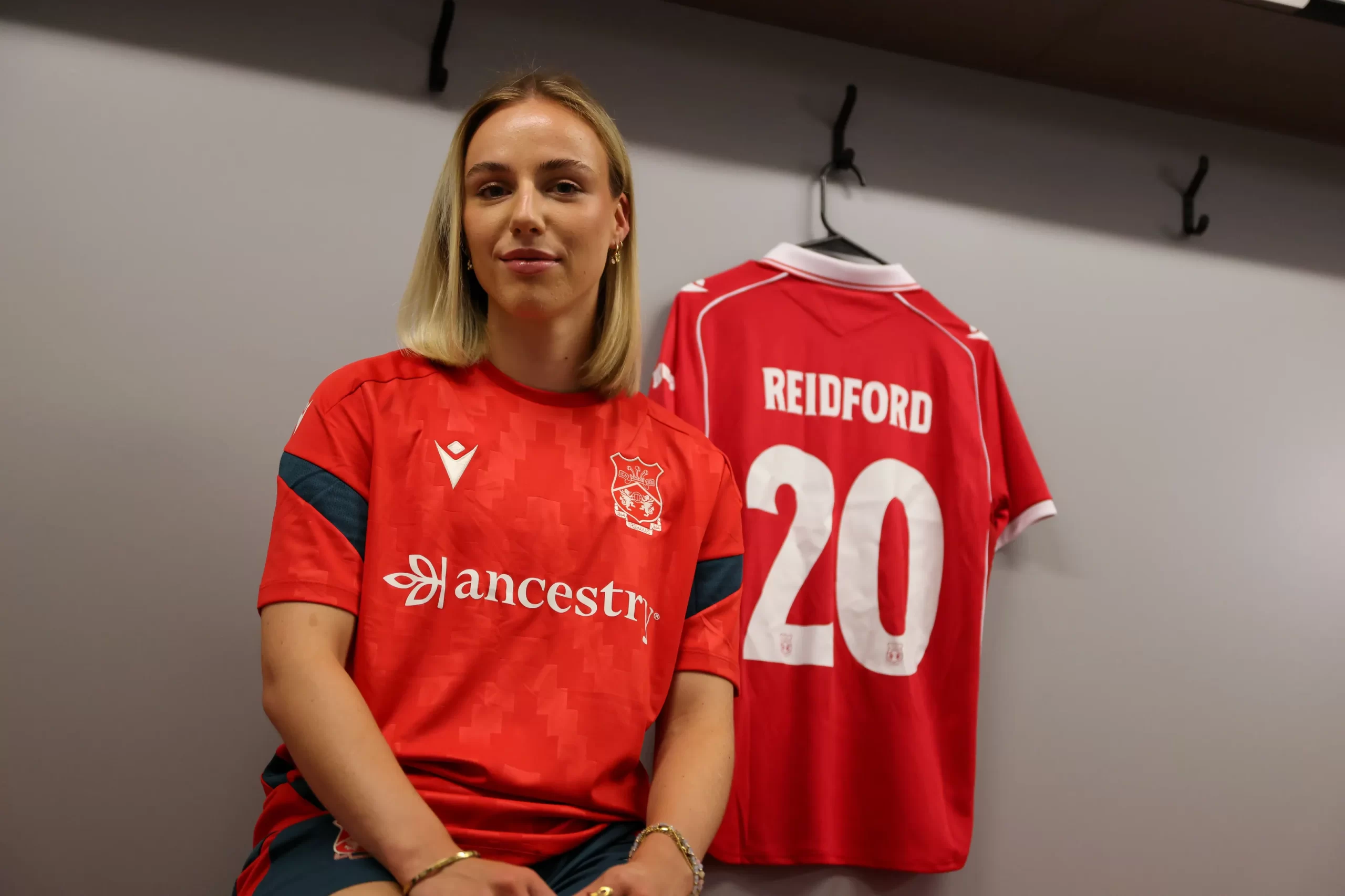 Bella Reidford poses next to a Wrexham shirt