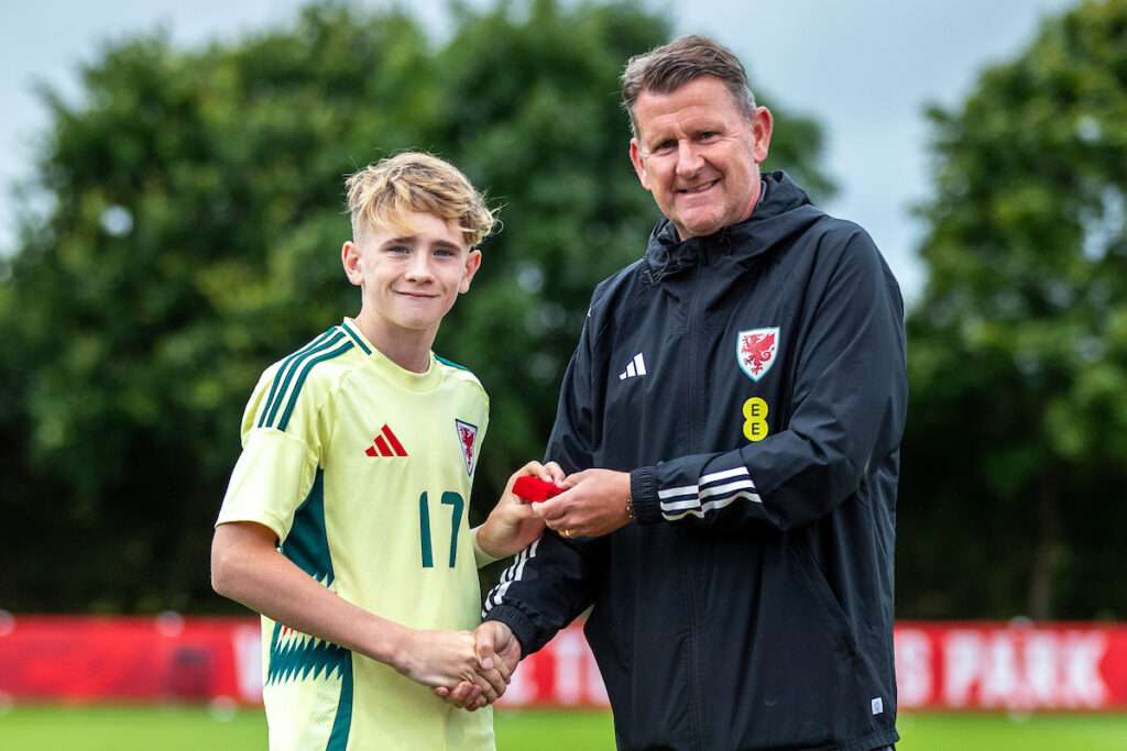 Cymru U17 Manager, Craig Knight presents Declan Devulgt of Team James following the 2024 Cymru Cup fixture between Team Ampadu and Team James at Colliers Park, Gresford, Wrexham