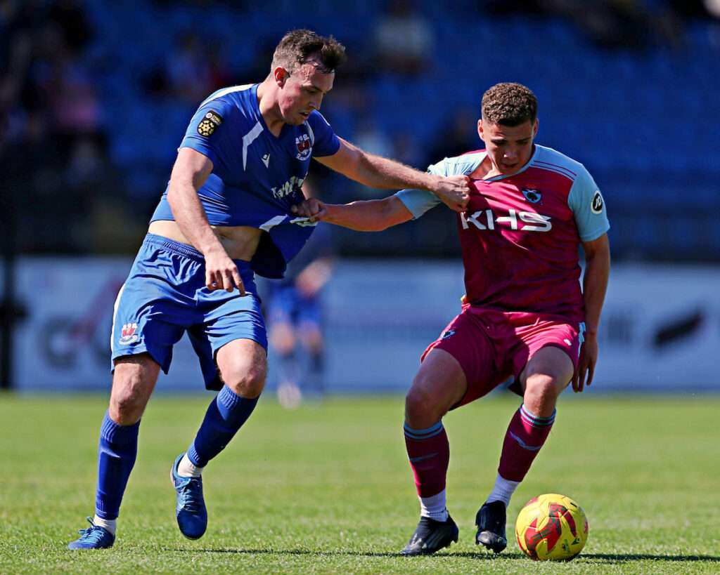 Billy Borge of Penybont FC pressures Alex Moore of Colwyn Bay FC during Colwyn Bay FC vs Penybont FC in the Semi-Final of the JD Cymru Premier European Play-Offs at the Blue Turtle Arena, Colwyn Bay