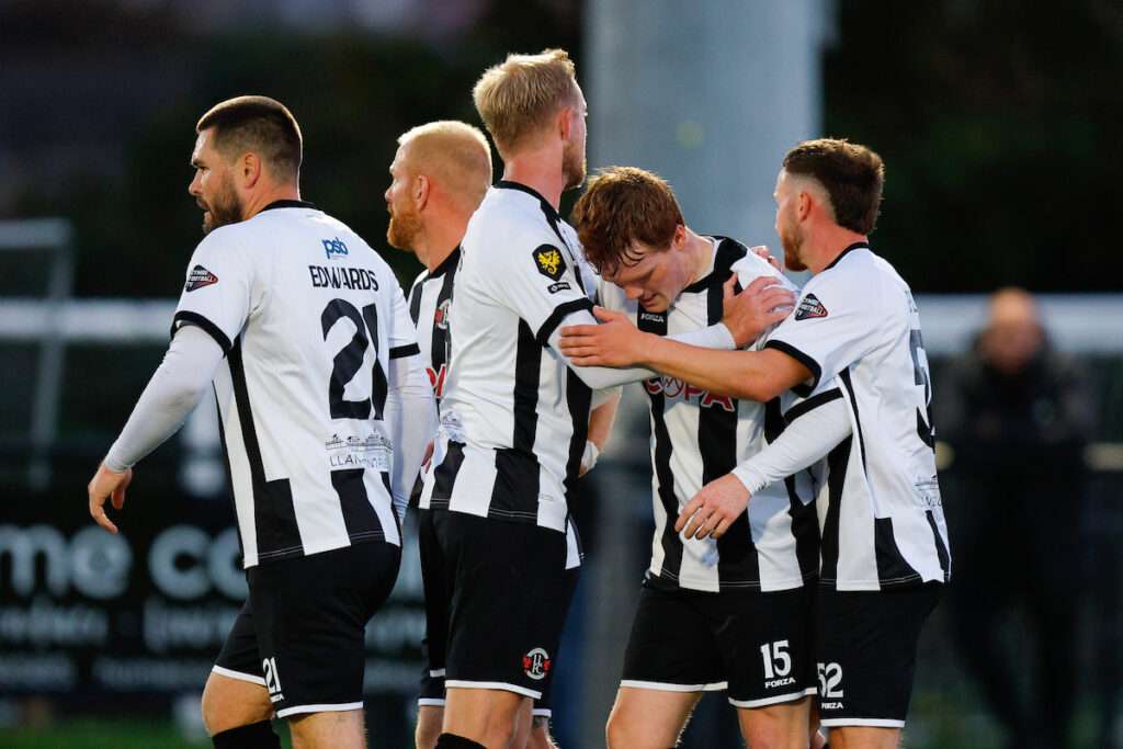 Nicholas Grogan of Llandudno Town celebrates with his team mates after scoring a goal to make it 1-0 during the Novira Cymru Premier game between Llandudno Town and Ammanford at the Go Goodwins Stadium in Llandudno