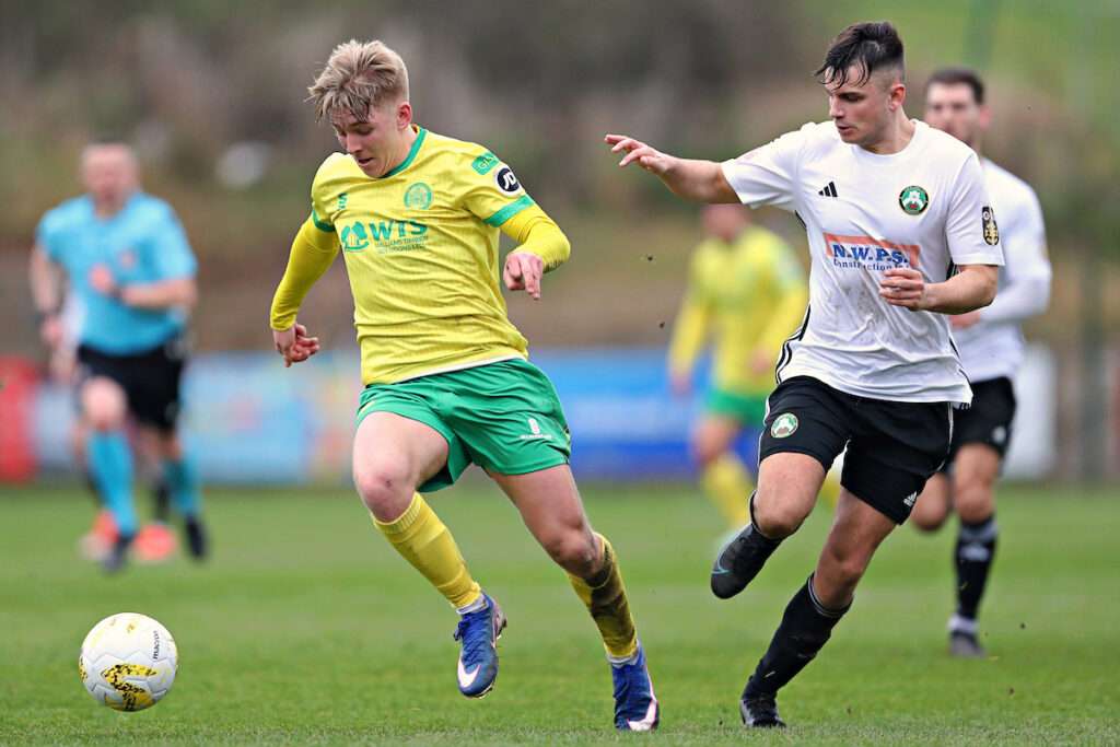 Ben Lawrence of Rhyl 1879 pressures Rio Owen of Caernarfon Town  during the JD Welsh Cup Semi-Final between Rhyl 1879 and Caernarfon Town at The Blue Turtle Arena in Colwyn Bay 