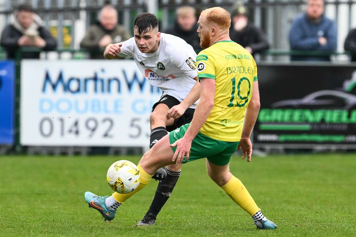 Ben Lawrence of Rhyl 1879 passes the ball during the JD Welsh Cup Semi-Final between Rhyl 1879 and Caernarfon Town at The Blue Turtle Arena in Colwyn Bay