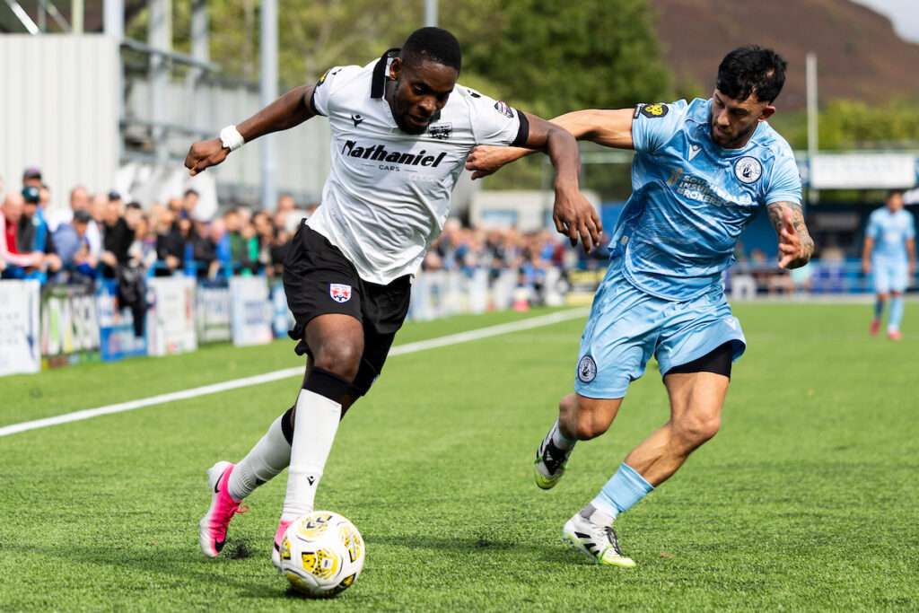 Penybont's Jonathan Leko in action against Cambrian United's Cam Strinati during the 2025/26 Novira Cymru Premier match between Cambrian United & Penybont at the M&P Group 3G in Clydach Vale, Wales