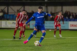 Haverfordwest County's Ben Ahmun puts the home side ahead from the penalty spot during the Novira Cymru Premier 2026/27 fixture Haverfordwest County vs Hollywell Town at Dynamite Bridge Meadow Stadium, Haverfordwest, Wales