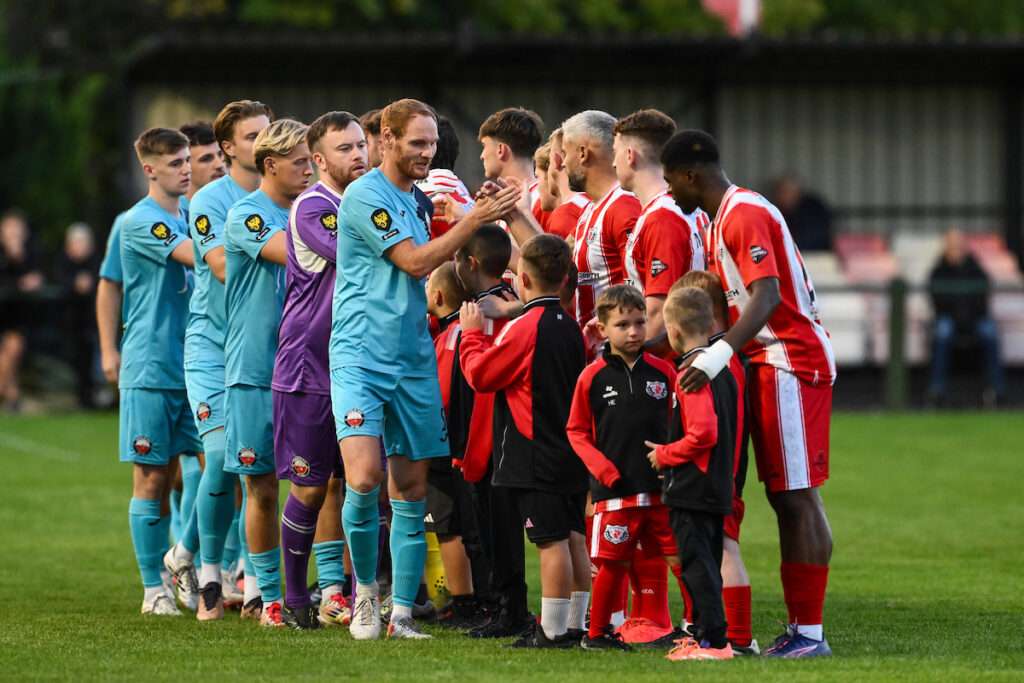 HOLYWELL, WALES - 04 SEPTEMBER 2026: Players shake hands ahead of the Novira Cymru Premier game between Holywell Town and Trefelin at the Bartons North Wales Stadium in Holywell. (Pic by Craig Thomas /FAW)
