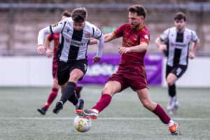 Trearddur Bay's Ryan Pryce tackles Flint Town United's Elliott Reeves during the JD Welsh Cup fixture between Flint Town United and Trearddur Bay at the Essity Stadium, Flint. 31st of January, Flint, Wales