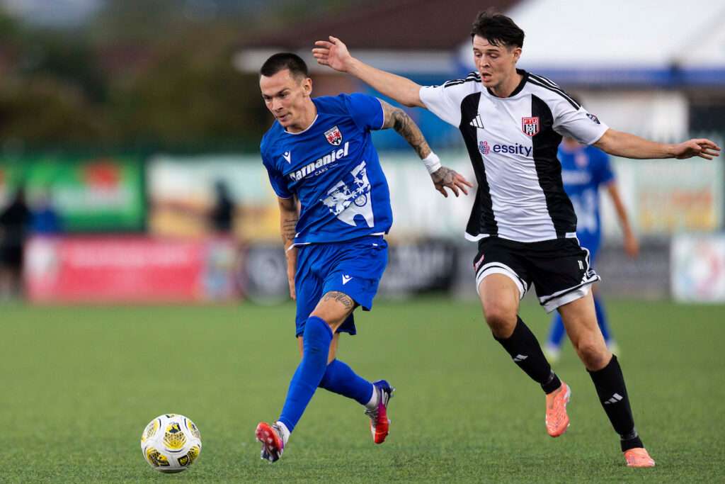 Ryan Hill of Penybont in action against Joe Malkin of Flint Town United during the Novira Cymru Premier match between Penybont & Flint Town United at the DragonBet Stadium, Bridgend, Wales