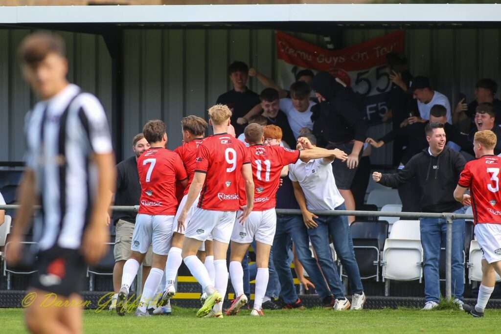 Caerau Ely players celebrate with supports after Lewis Harling's goal against Cardiff Dracs in the Cymru South