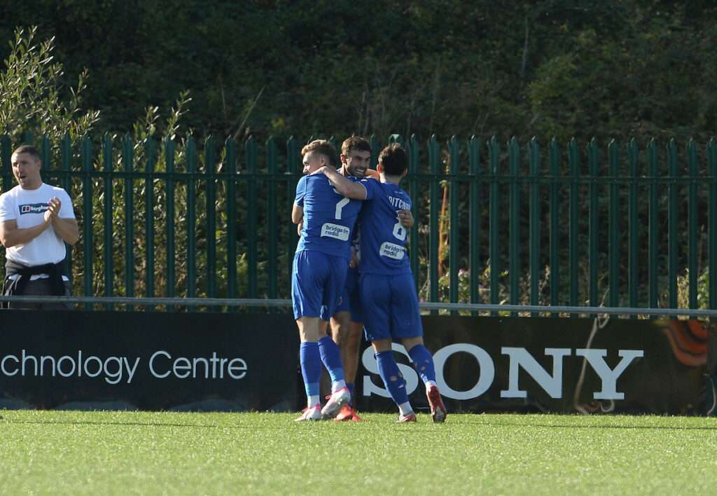 Ethan Cann celebrates with his teammates after scoring Penybont's second goal against Airbus UK Broughton in the Cymru Premier
