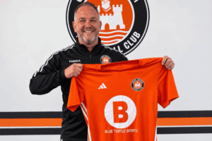 Ronnie Green holds up a Conwy Borough shirt