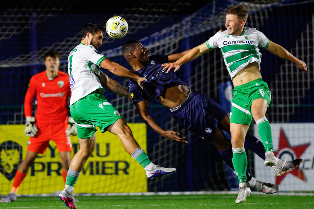 BROUGHTON, WALES - 16 OCTOBER 2026: Jordan Williams and Jack Bodenham of The New Saints challenge Brandon Diau of Airbus UK Broughton during the Welsh Cup Second Round game between Airbus UK Broughton and The New Saints at The Hollingsworth Group Stadium in Broughton