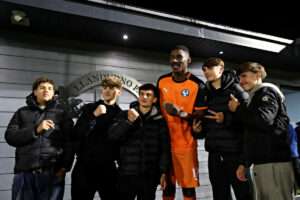 Airbus UK Broughton's Brandon Diau with fans after Llandudno FC vs Airbus UK Broughton in Round 13 of the Novira Cymru Premier at the Go Goodwins Stadium, Llandudno