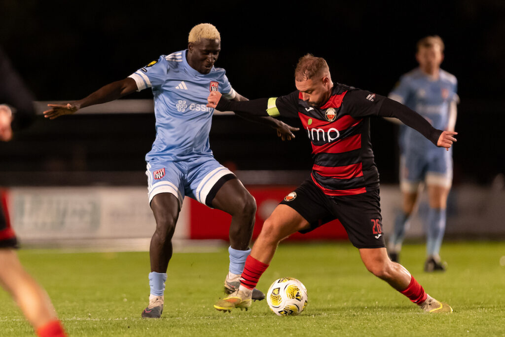 , Lassana Mendes of Flint Town United and Kane Owen of Trefelin BGC battle for the ball during the Novira Cymru Premier